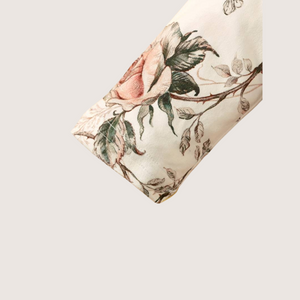 Close-up of floral baby girl romper sleeve with rose print