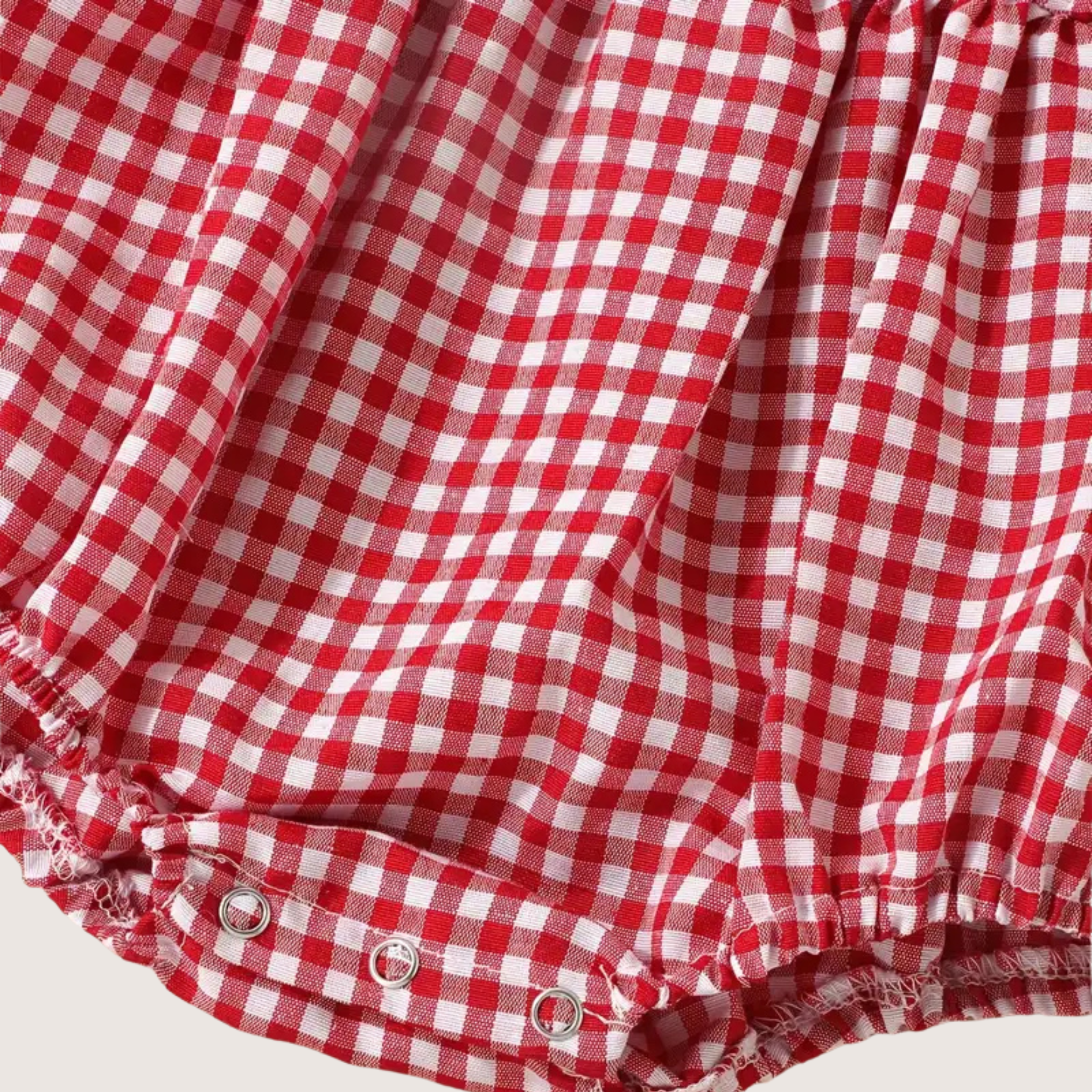 Snap closure at bottom of gingham baby romper