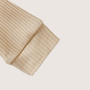 Close-up of snap closure on beige ribbed baby romper for easy diaper change
