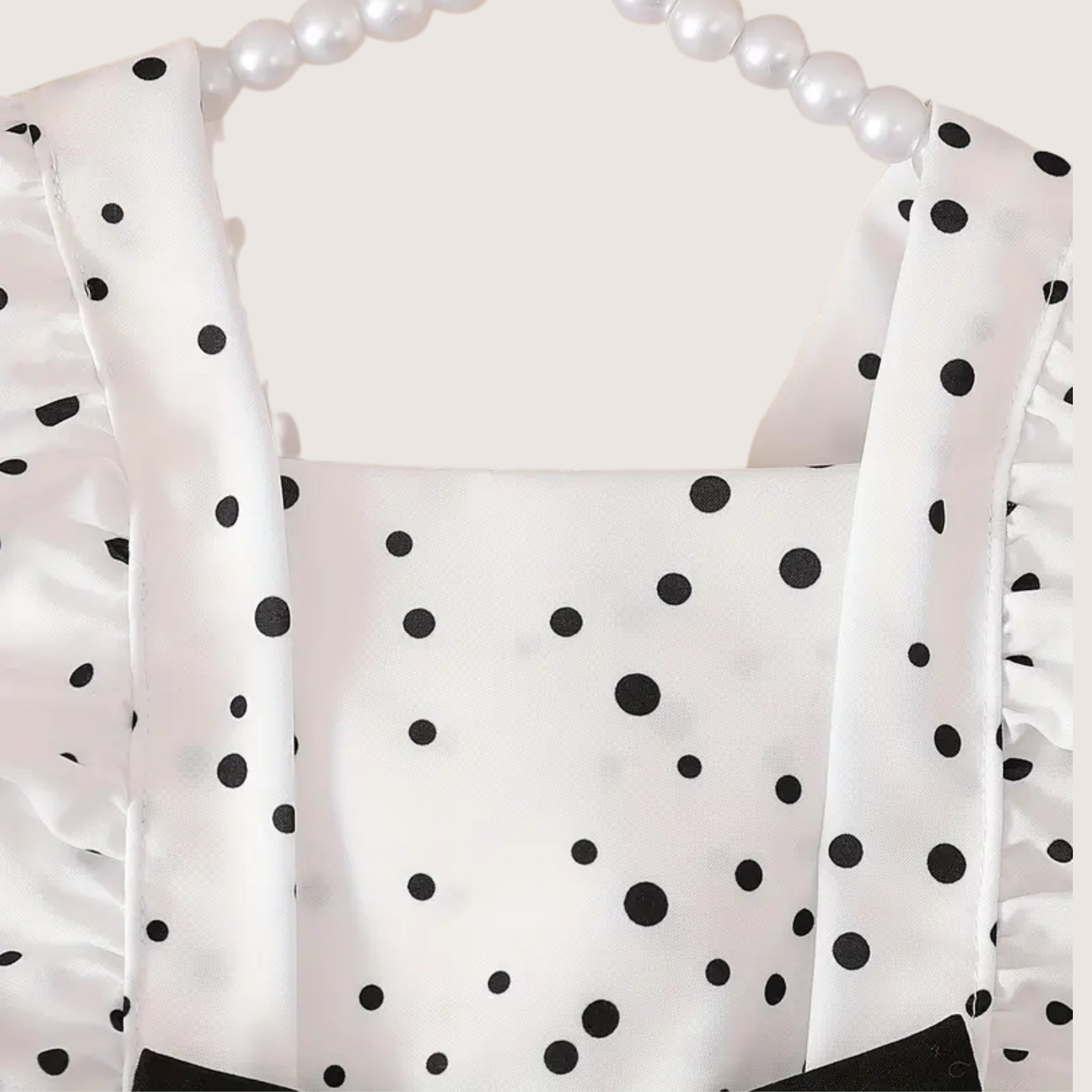 Close-up of elegant black bow on baby girl polka dot romper
