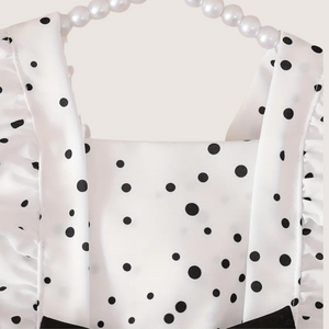 Close-up of elegant black bow on baby girl polka dot romper
