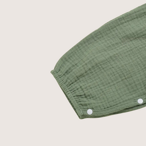 Close-up of olive green baby girl romper sleeve with snap buttons